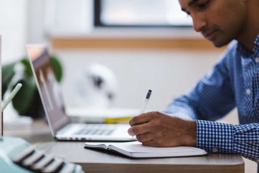 man, writing, laptop