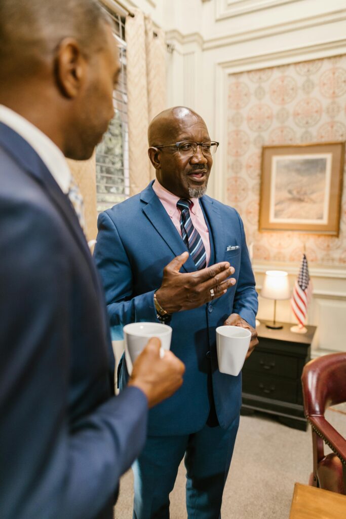 Two professionals having a discussion in an office with American flag decor.